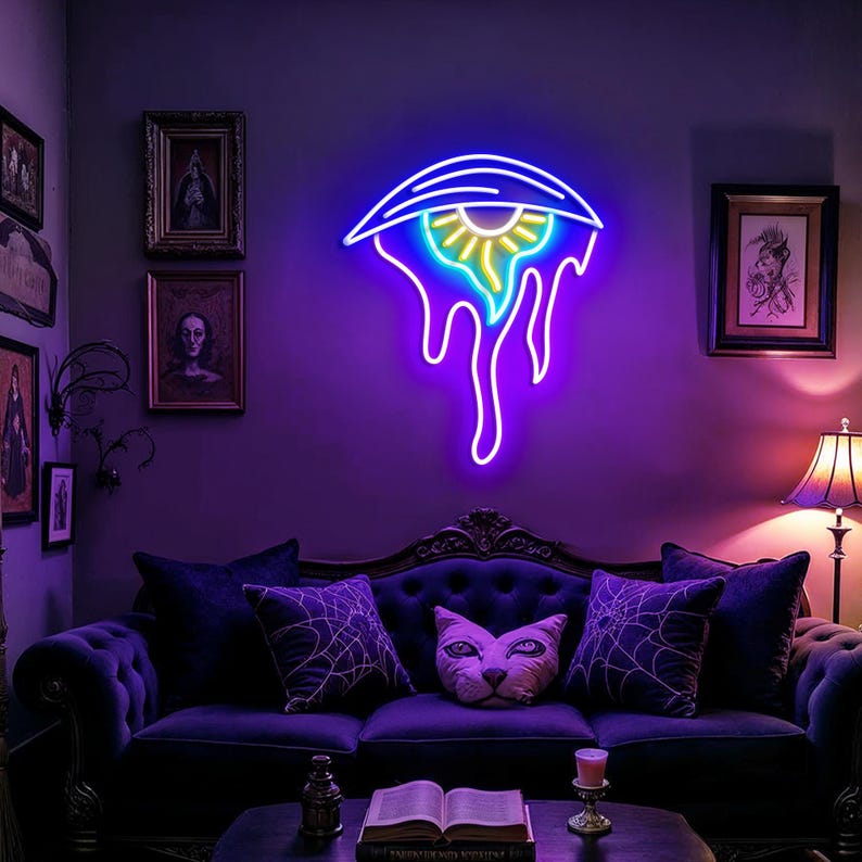May include: A neon eye-shaped sign with a blue outline and yellow and green centre, mounted on a purple wall. The eye is dripping with neon purple liquid. The room has a dark purple sofa and decorative cushions.