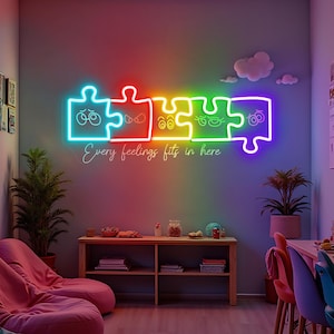 Può includere: Un cartello al neon a forma di pezzi di puzzle con volti e occhi di diversi colori. Il cartello recita "Every feelings fits in here".
