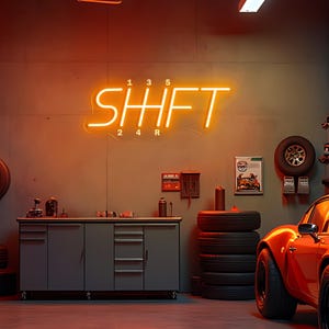 May include: An orange neon sign that reads "SHIFT" with gear shift numbers above and below. The sign is mounted on a gray wall in a garage setting. A red sports car is parked on the right.