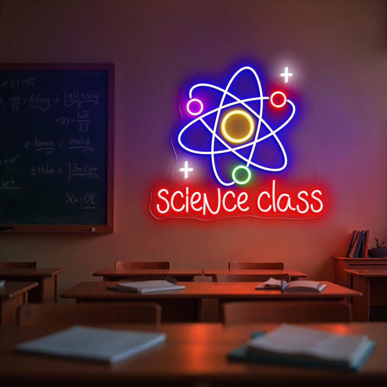 May include: A neon sign in a classroom setting displays a stylized atom symbol with orbiting electrons in blue, pink, red, and green. The words "science class" are in red below the atom symbol. The background includes wooden desks and a chalkboard.