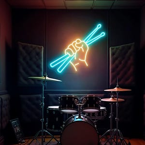 Op de afbeelding: Een drumstel in een zwak verlichte kamer met een neonbord met een hand die drumstokken vasthoudt. De set bevat een basdrum, snare en toms. Bekkens zijn op statieven gemonteerd. Het neonbord is oranje en blauw.