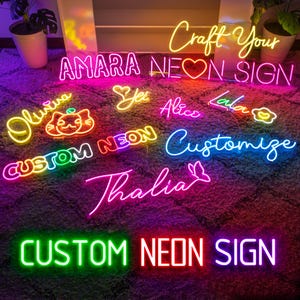 K&ouml;nnte beinhalten: Eine Sammlung von benutzerdefinierten Neon-Schildern mit verschiedenen Farben und Designs. Die Schilder beinhalten Namen wie "Amara", "Olivia", "Yer", "Alice", "Lala", "Thalia" und "Customize". Die Schilder zeigen auch eine Katze, ein Herz und eine Blume. Der Text "Craft Your Neon Sign" und "Custom Neon Sign" ist ebenfalls sichtbar.