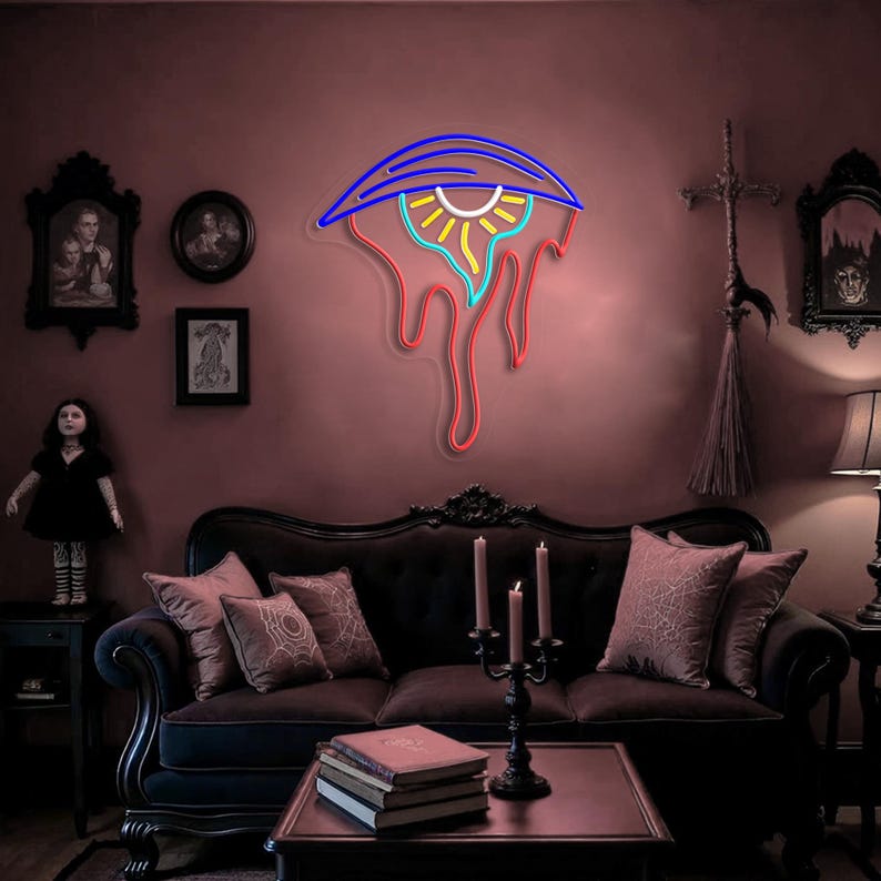 May include: A neon eye-shaped sign with blue, yellow, and red lights, mounted on a dark red wall. The room features a black sofa, antique decor, and a gothic theme. The sign's design includes dripping elements.