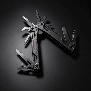 May include: A matte black multi-tool featuring an array of deployed implements including pliers, a serrated saw blade, a straight blade, and various drivers. The metal frame displays geometric textures and mechanical pivot points throughout the design.