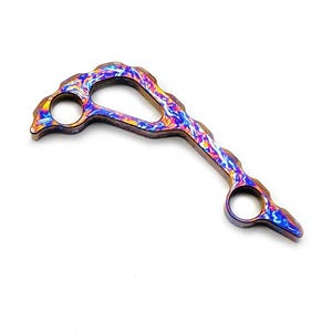 Peut inclure: Un outil métallique incurvé doté de deux trous circulaires pour les doigts et d'un bord irrégulier et ondulé. La surface présente une finition anodisée aux couleurs vives avec des motifs tourbillonnants de bleu, violet, orange et jaune.