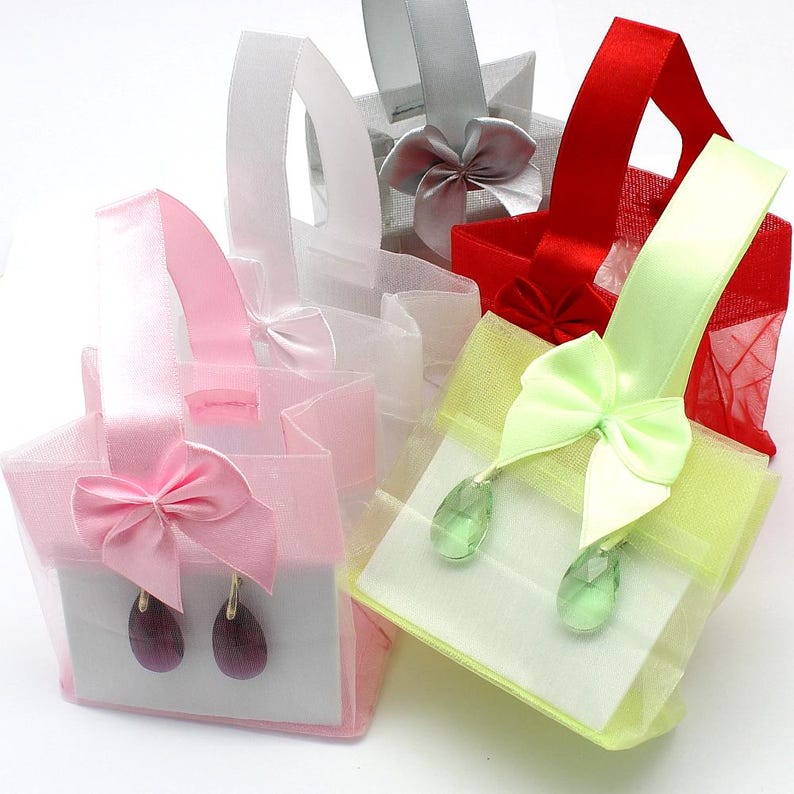 May include: Assortment of small, sheer gift bags with satin ribbon bows and earrings inside. The bags are in pink, white, green, and red.