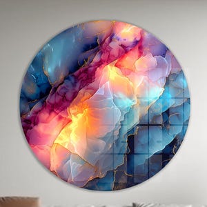 Pu&ograve; includere: Un'opera d'arte rotonda da parete con un design astratto. L'opera presenta una miscela di colori, tra cui blu, rosa, arancione e oro. Il design ricorda un acquerello o un primo piano di una pietra preziosa. L'opera &egrave; montata su una parete bianca.
