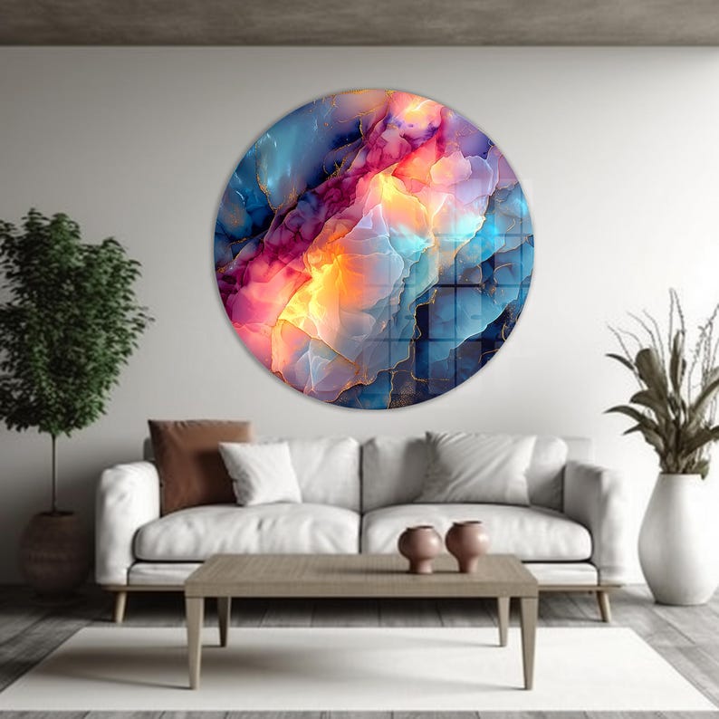 Pu&ograve; includere: Un'opera d'arte rotonda da parete con un design astratto. L'opera presenta una miscela di colori, tra cui blu, rosa, arancione e oro. Il design ricorda un acquerello o un primo piano di una pietra preziosa. L'opera &egrave; montata su una parete bianca.