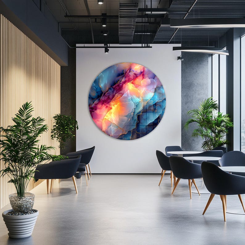 Pu&ograve; includere: Un'opera d'arte astratta circolare di grandi dimensioni con una vivace miscela di colori, tra cui blu, rosa e giallo, &egrave; appesa a una parete bianca. L'opera d'arte &egrave; il punto focale di uno spazio interno moderno, completato da sedie, tavoli e piante in vaso.