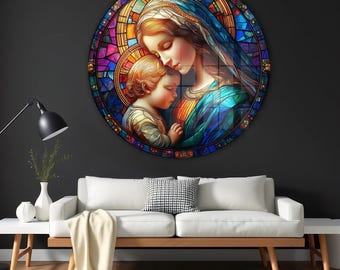 May include: A round stained glass art piece depicting a mother and child in a loving embrace. The artwork features vibrant colors, including blues, oranges, and purples, and is mounted on a dark gray wall above a white sofa.