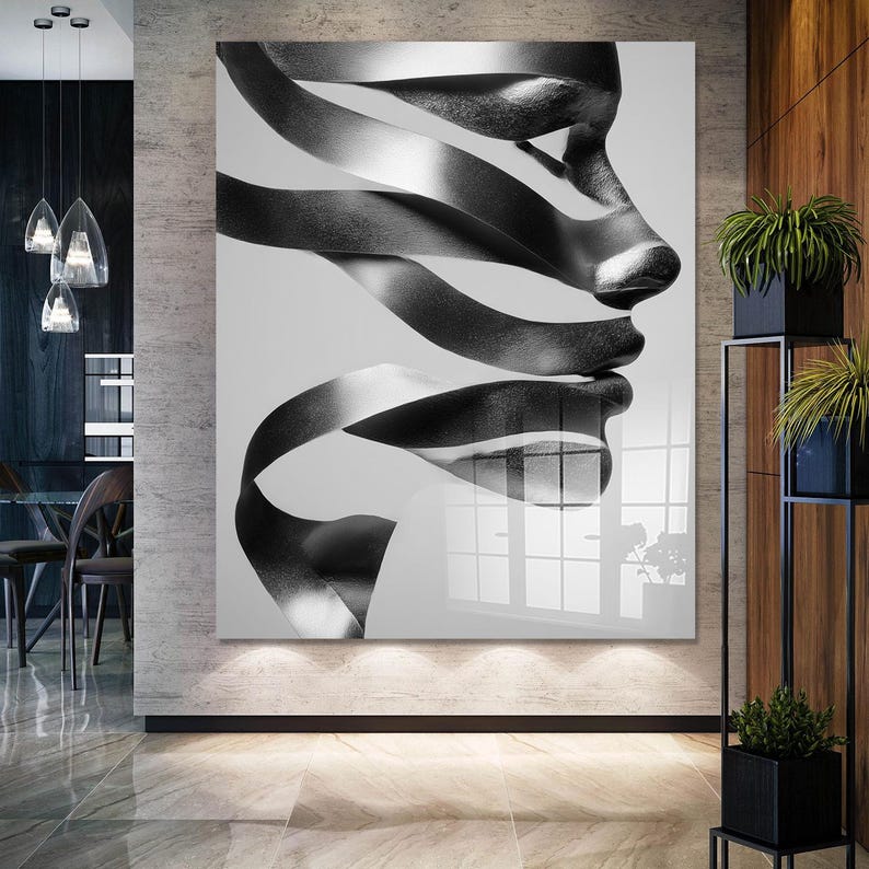 May include: Black and white abstract art print featuring a profile of a face created from flowing ribbons. The artwork is displayed on a large, glossy panel, creating a modern and artistic statement piece for interior decor.