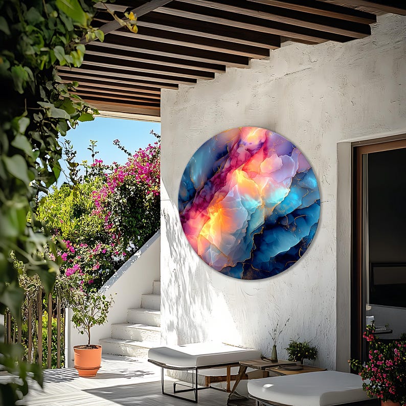 Pu&ograve; includere: Un'opera d'arte murale rotonda con un vivace design astratto. L'opera presenta una miscela di colori, tra cui blu, rosa, arancione e oro, creando una composizione visivamente sorprendente e dinamica. L'opera &egrave; montata su un muro bianco.