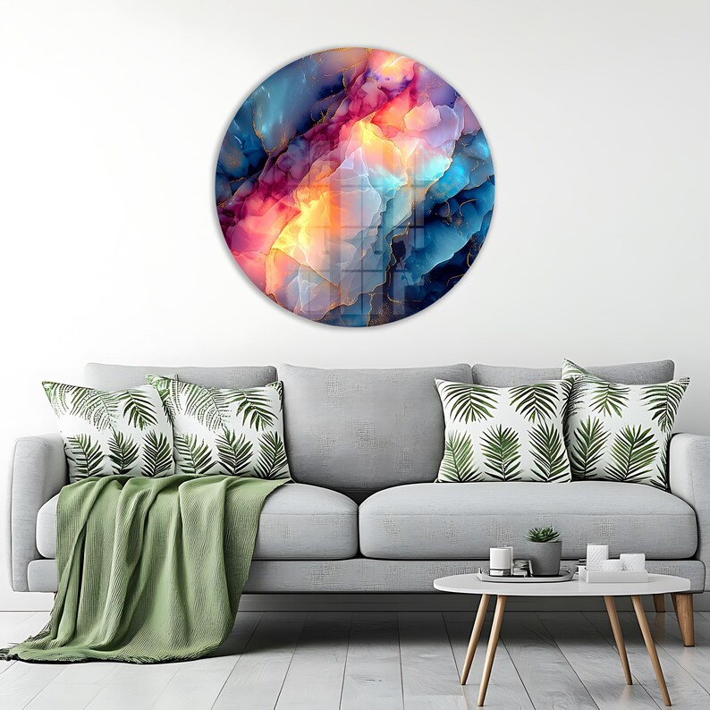 Pu&ograve; includere: Un'opera d'arte murale rotonda con un design astratto. L'opera presenta una miscela di colori, tra cui blu, rosa, arancione e oro, creando un effetto visivo dinamico. Il pezzo &egrave; montato su una parete bianca.