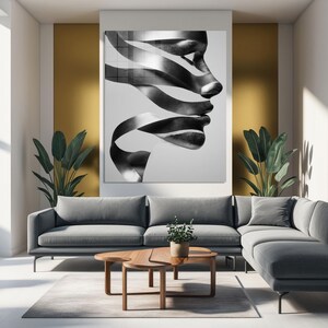 May include: Black and white abstract art print featuring a profile of a face with ribbon-like elements. The artwork is displayed above a gray sofa, with a wooden coffee table and plants in the room. The overall theme is modern home decor.