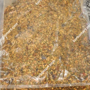 May include: A clear plastic bag filled with a mixture of dried herbs and spices. The mixture is a blend of yellow, green, red, and brown colors.