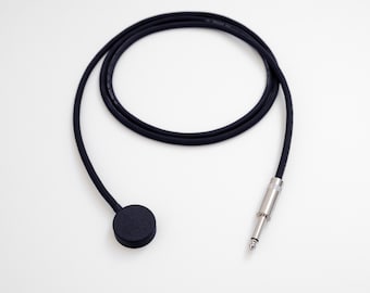 May include: A black microphone pickup with a round, black pickup and a black cable with a 1/4 inch jack.