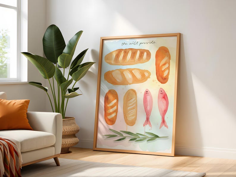 May include: A framed watercolour print depicting different loaves of bread and two pink fish. The words "he will provide" are at the top. The artwork is in a wooden frame and leans against a white wall.