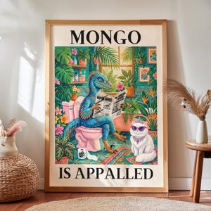Könnte beinhalten: Ein gerahmter Kunstdruck mit dem Titel MONGO IS APPALED zeigt einen blauen, gefiederten Dinosaurier auf einer rosa Toilette, der eine Zeitung liest, begleitet von einer weißen, flauschigen Katze mit Diadem und violetter Brille, umgeben von Pflanzen.
