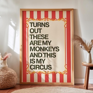 May include: A framed poster with a cream background and red and white stripes. The poster has the text "TURNS OUT THESE ARE MY MONKEYS AND THIS IS MY CIRCUS". Decorative gold flourishes frame the text.