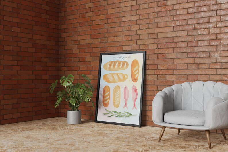 May include: A framed watercolour print depicting different types of bread, fish, and olive branches. The artwork is set against a brick wall, with a potted plant and a grey armchair. The print includes the text "the wild pantry".
