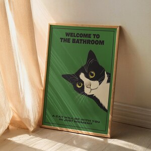 Funny tuxedo cat bathroom print — green framed decorative poster with a black-and-white cat; perfect restroom wall art for cat lovers.