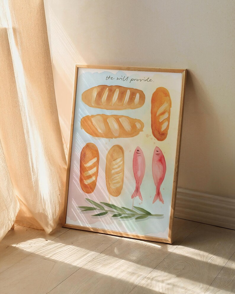May include: Framed watercolour print depicting several bread loaves, two pink fish, and a green sprig. The cursive text at the top reads "he will provide". The background has a soft, colourful gradient.