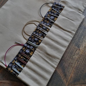 knitting needle case for interchangeable circular needles and crochet hooks, with a small zip bag on the side for notions and accessories