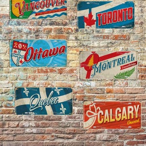 May include: A collection of vintage-style metal license plates featuring Canadian city names: Vancouver, Toronto, Ottawa, Montreal, Quebec, and Calgary. Each plate has a unique design with city names and decorative elements, set against a brick wall background.