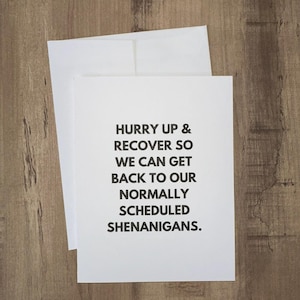 May include: White card with black text that reads "Hurry up & recover so we can get back to our normally scheduled shenanigans."
