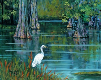 May include: A white egret stands in a swamp with tall, green trees and blue water. The water reflects the trees and sky.