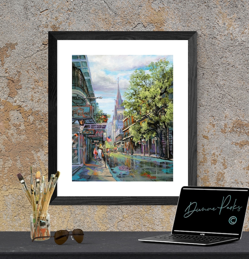 May include: A painting of a street scene in New Orleans, Louisiana. The painting features a narrow street lined with buildings, a large tree, and a church in the distance. The street is wet from recent rain, and there are people walking on the sidewalk.