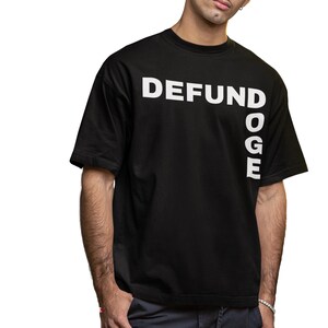 May include: Black t-shirt with white text that reads "DEFUND" and "DOGE" vertically.