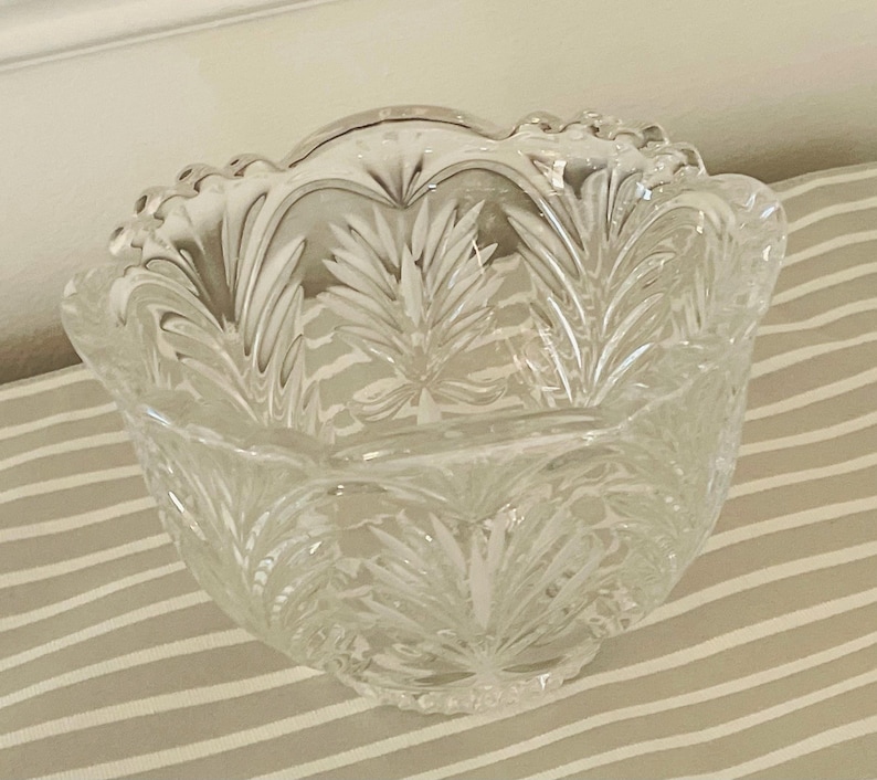 Peut inclure: Un bol en verre transparent avec un bord festonn&eacute; et un motif d&eacute;taill&eacute; de feuilles de foug&egrave;re. Le bol a une forme arrondie et est probablement utilis&eacute; pour servir ou d&eacute;corer. Le verre transparent laisse passer la lumi&egrave;re.