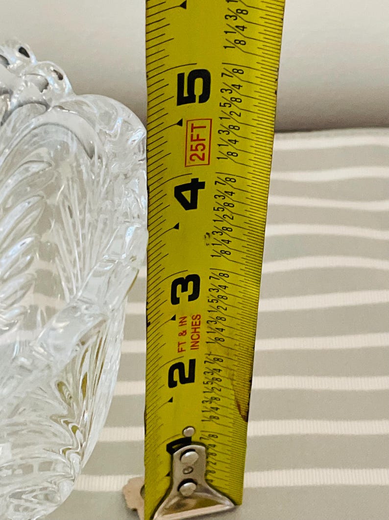 Peut inclure: Un bol en verre clair et d&eacute;coratif avec un motif textur&eacute; en forme de feuille. Un ruban &agrave; mesurer jaune indique que la hauteur du bol est d'environ 10 cm. Le ruban est gradu&eacute; en pieds et en pouces.