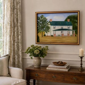 May include: A rectangular painting in a gold frame depicting a white two-story house with a dark green roof and a front porch. The house is set against a blue sky with clouds, surrounded by green trees and a tan field in a landscape scene.