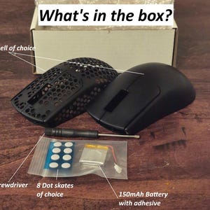 May include: An opened box reveals the contents of a gaming mouse kit. The kit includes a black mouse shell, a black perforated mouse shell, a screwdriver, 8 dot skates, and a 150mAh battery with adhesive. The text "What's in the box?" is visible.