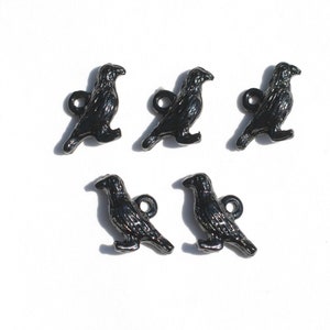 May include: Five black crow charms with a shiny finish. Each charm has a loop for attaching to a necklace, bracelet, or other jewellery.