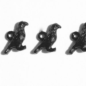 May include: Three black crow buttons with a shiny finish. Each button features a detailed crow design with a small loop for attaching.