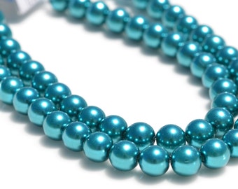 May include: A strand of teal blue pearl beads. The beads are round and have a metallic sheen.
