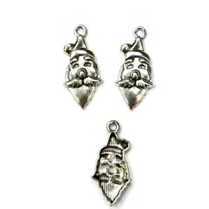 May include: Three silver charm pendants featuring a Santa Claus face. The charms are detailed with a white beard, red hat, and a smiling face.