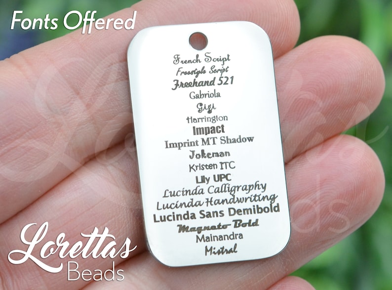 May include: A silver metal tag with a list of fonts, including French Script, Freestyle Script, Freehand 521, Gabriola, Gigi, Harrington, Impact, Imprint MT Shadow, Jokeman, Kristen ITC, Lily UPC, Lucinda Calligraphy, Lucinda Handwriting, Lucinda Sans Demibold, Magnato Bold, Mainandra, and Mistral.