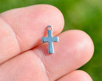 May include: A silver cross charm pendant. The cross is simple and has a smooth, polished finish.