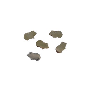 May include: Five silver-colored metal charms shaped like guinea pigs. The charms are all facing the same direction and have a slightly textured surface.