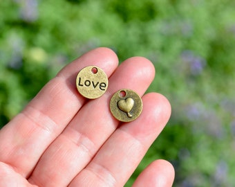 May include: Two gold-toned metal charms, one with the word "Love" and the other with a heart shape.