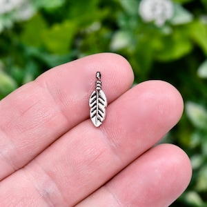 May include: A silver feather charm pendant, ideal for jewellery making or crafting projects.