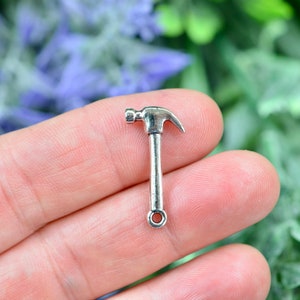 May include: Silver-toned metal hammer charm with a loop at the end of the handle.