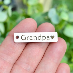 May include: Silver metal tag with the word "Grandpa" and a heart cutout.