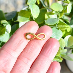 Lote de 50 dijes Infinity Gold Tone de 23 mm GC3546