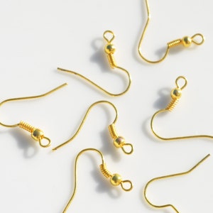 May include: Six gold-toned earring hooks with a spring-loaded closure. The hooks are made of metal and have a smooth finish.