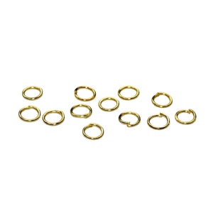May include: A collection of 13 gold jump rings, perfect for jewelry making or crafting projects.
